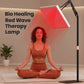 Red light therapy lamp with a rectangular LED panel on an adjustable black stand, glowing red above a seated woman
