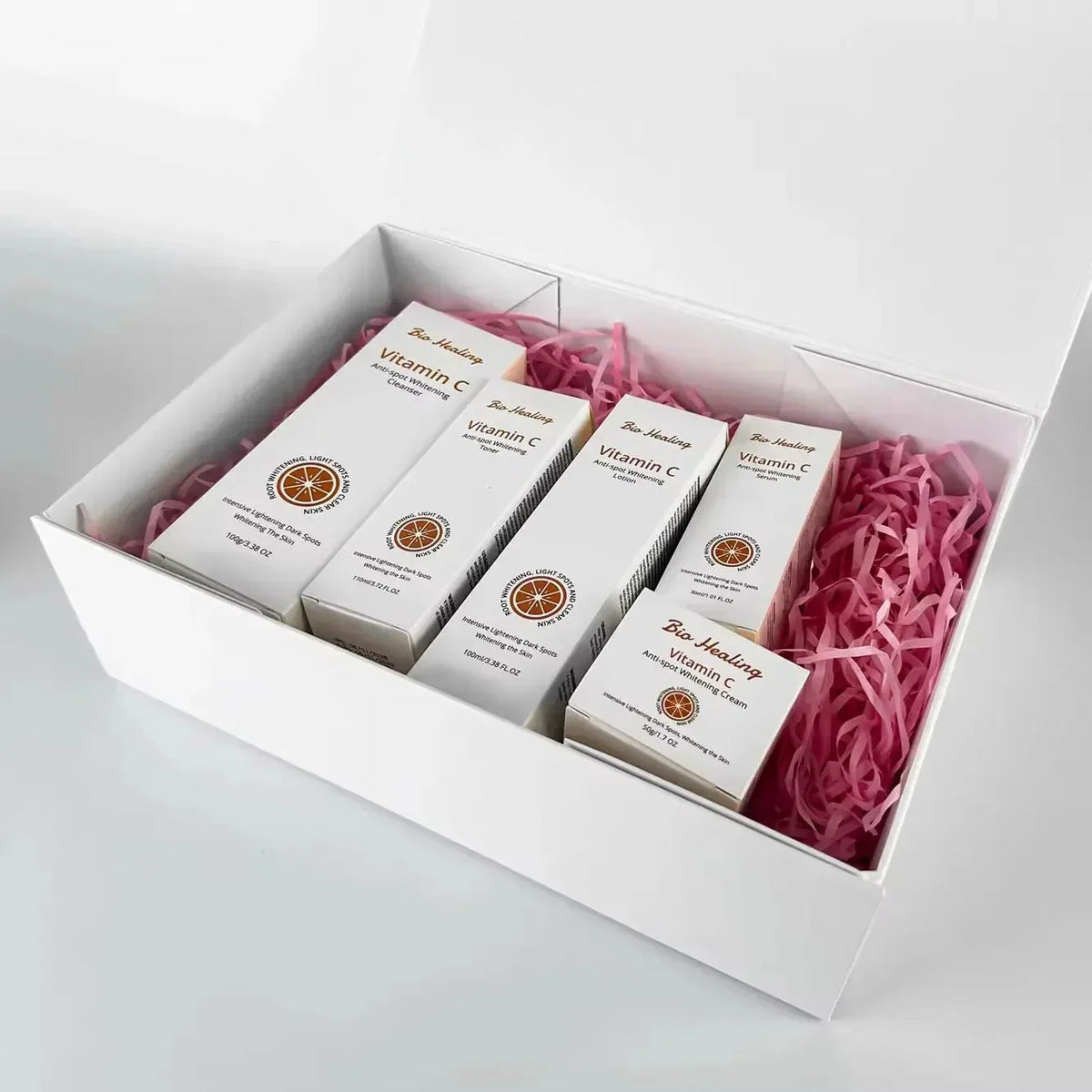 Vitamin C skincare set, VC Dark Spot Whitening Set, with five white cartons and orange citrus emblems in a gift box.