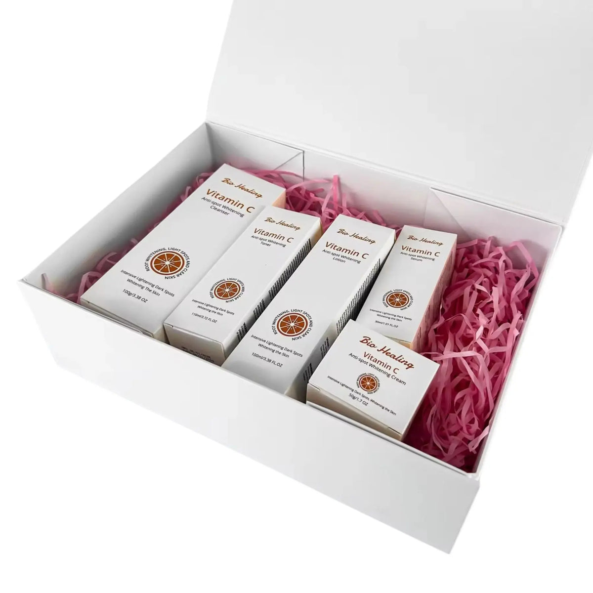 VC Dark Spot Whitening Set in white Vitamin C skincare cartons with orange citrus emblems, packed in a gift box with pink shred fill.